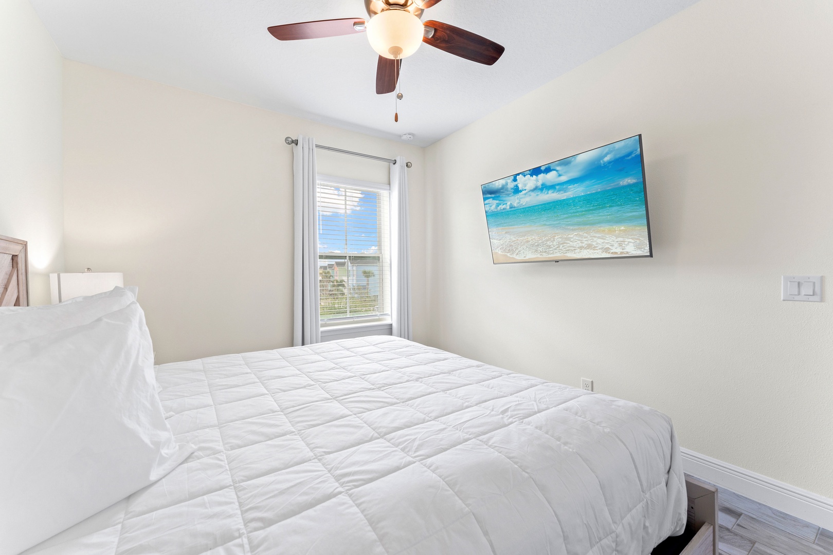 Relax in the third bedroom, showcasing a king bed & Smart TV