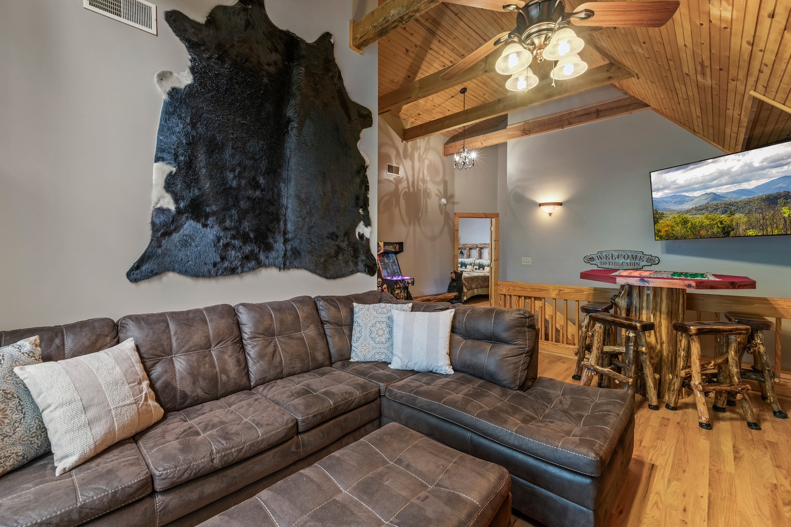 Upstairs living area with sectional sofa, card table, arcade game, and Smart TV