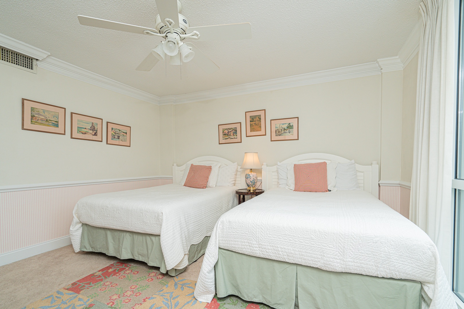 The second bedroom retreat offers two plush full beds, a TV, & beach views