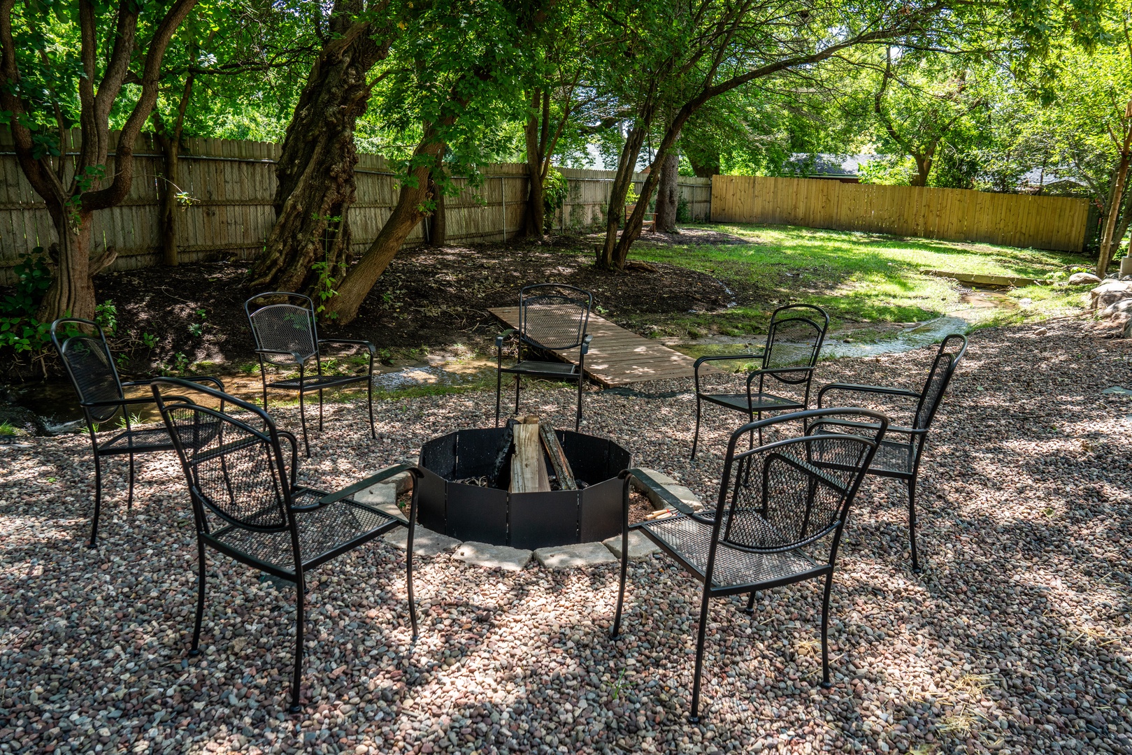 Backyard with firepit and propane grill on the back patio.