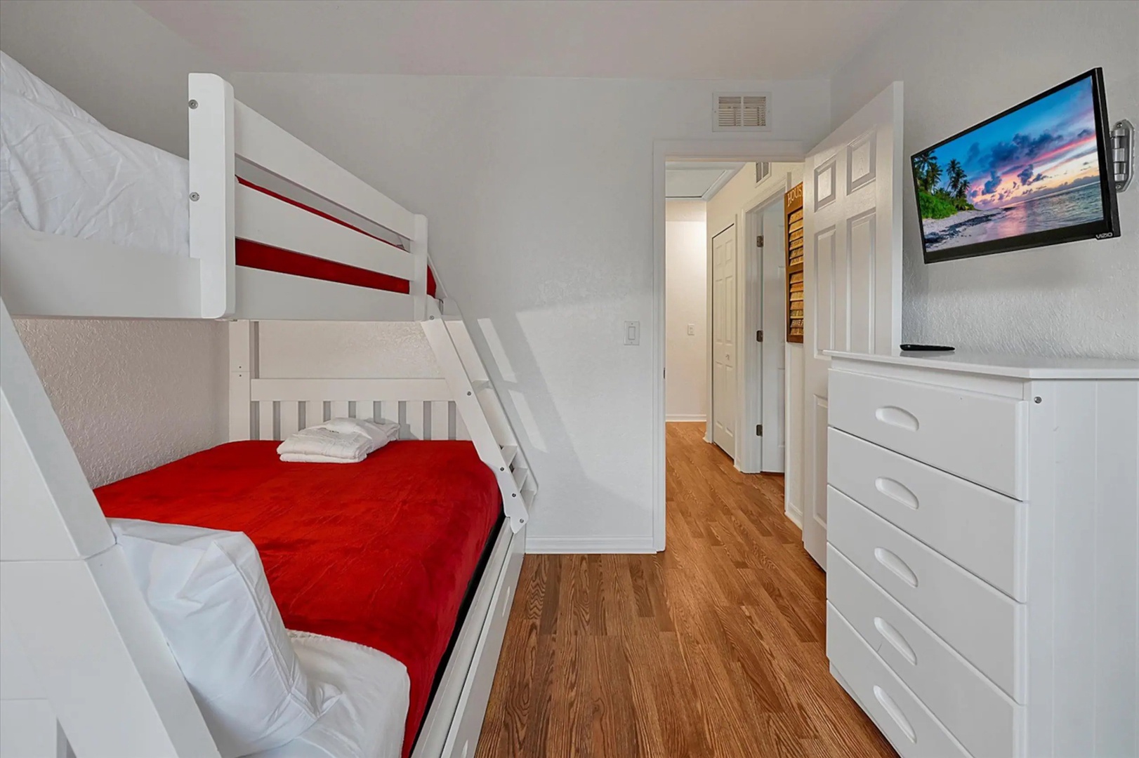 A twin-over-full bunkbed, twin trundle, & TV await in this 2nd-floor bedroom