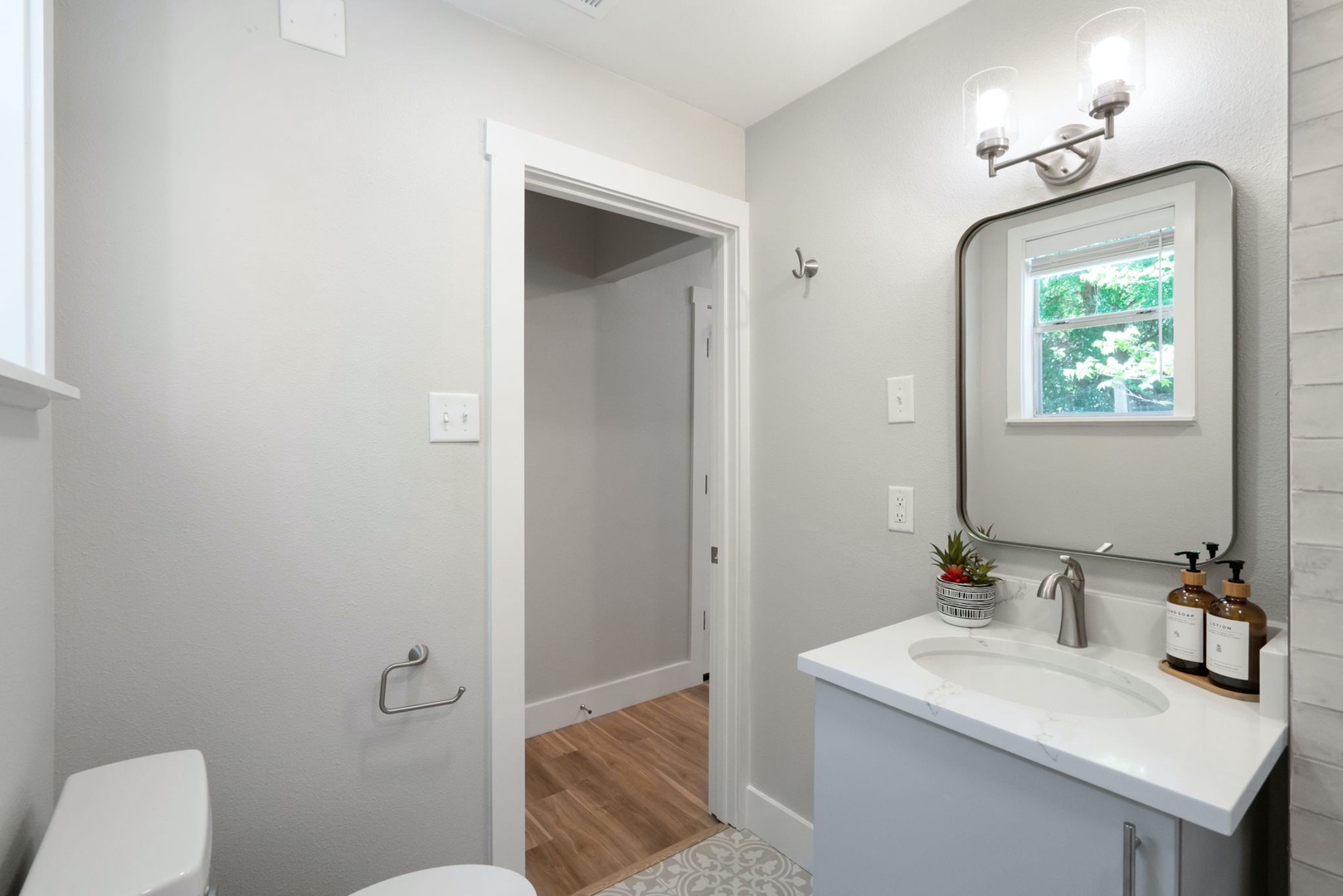 The stylish full bathroom features a single vanity & shower/tub combo
