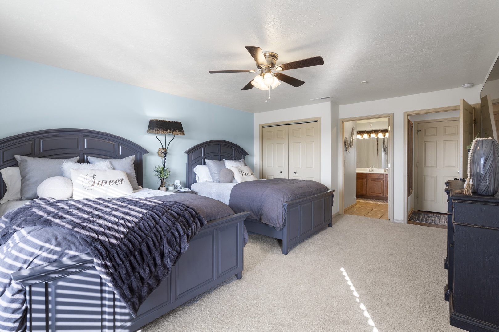 The master suite features a pair of queen beds, private ensuite, balcony access, & TV