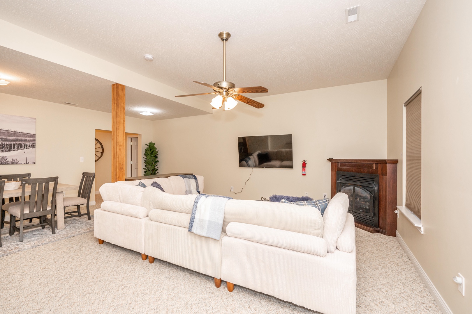 Basement living area with ample seating, additional dining table, and Smart TV