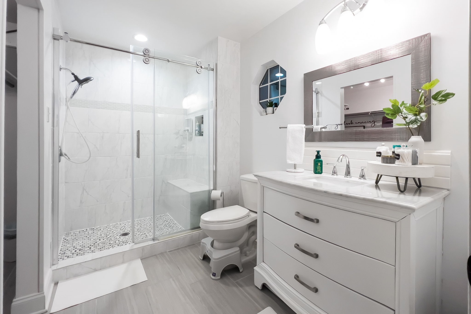 This polished ensuite includes a large single vanity & glass shower