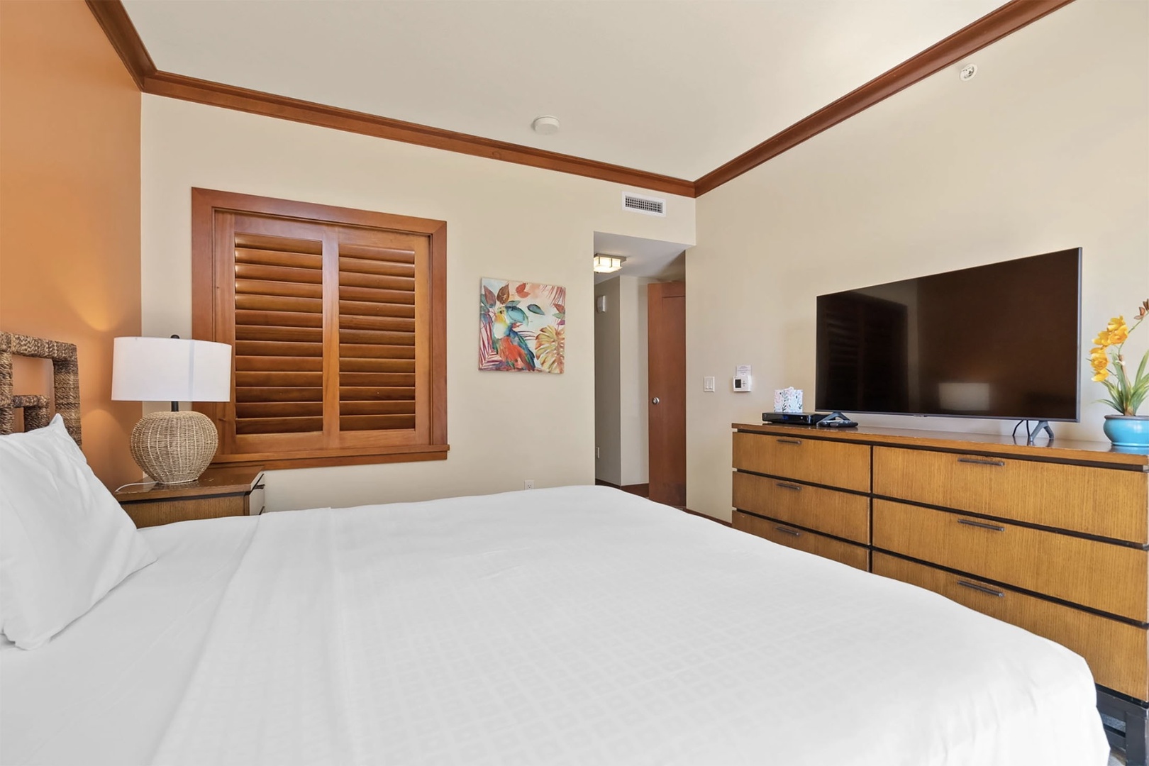 Primary bedroom features a king bed, balcony, ensuite bathroom, and TV