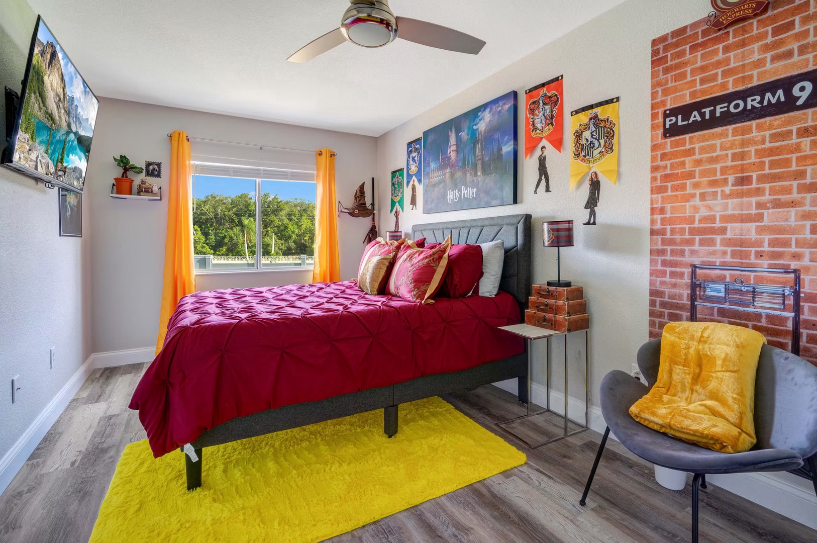 Cozy queen bed with Harry Potter magic, overhead fan, and a comfy chair