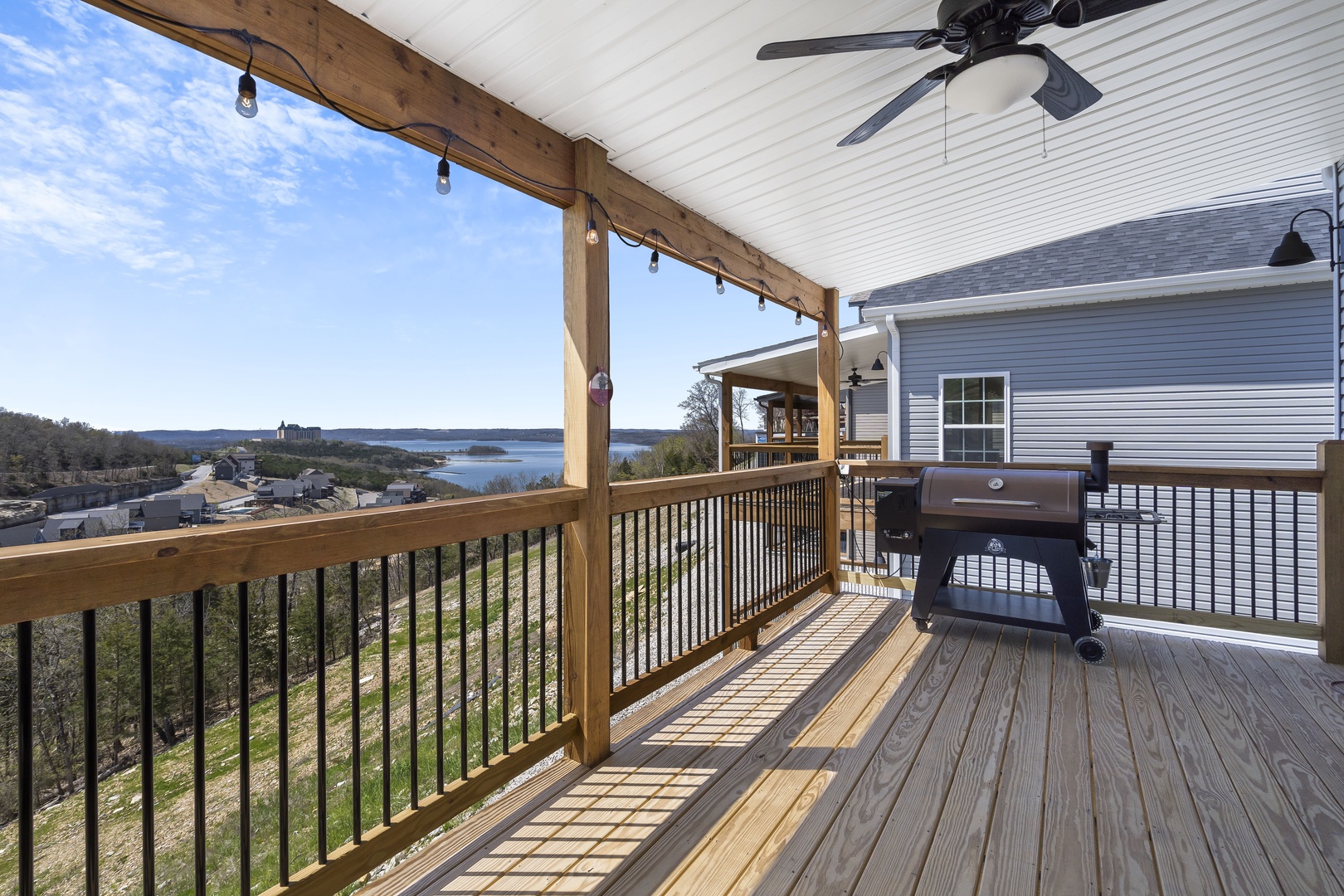 Large deck with outdoor seating, BBQ, and beautiful lake views