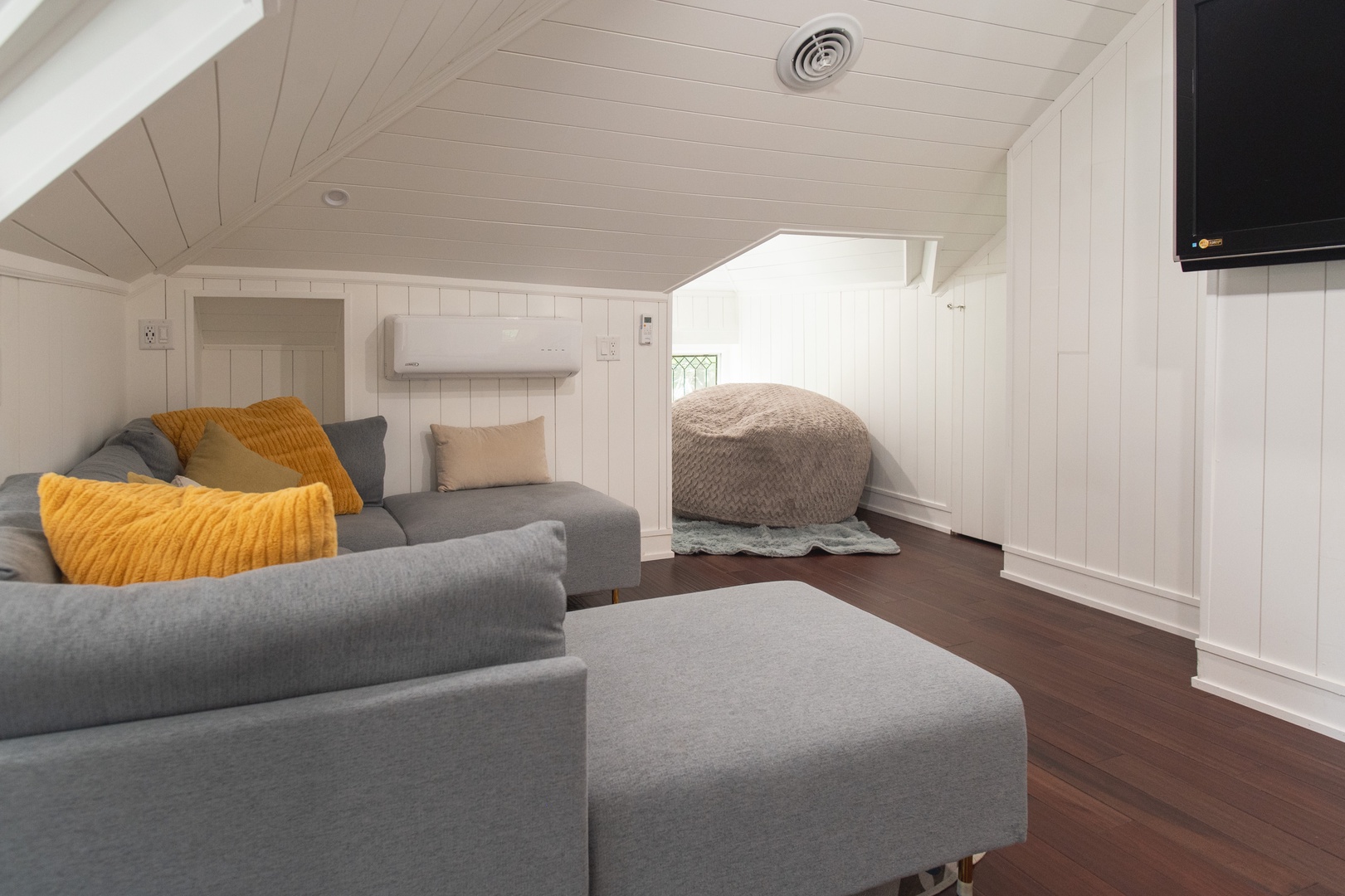 The main house’s loft area offers a Smart TV, reading nook, & full bathroom