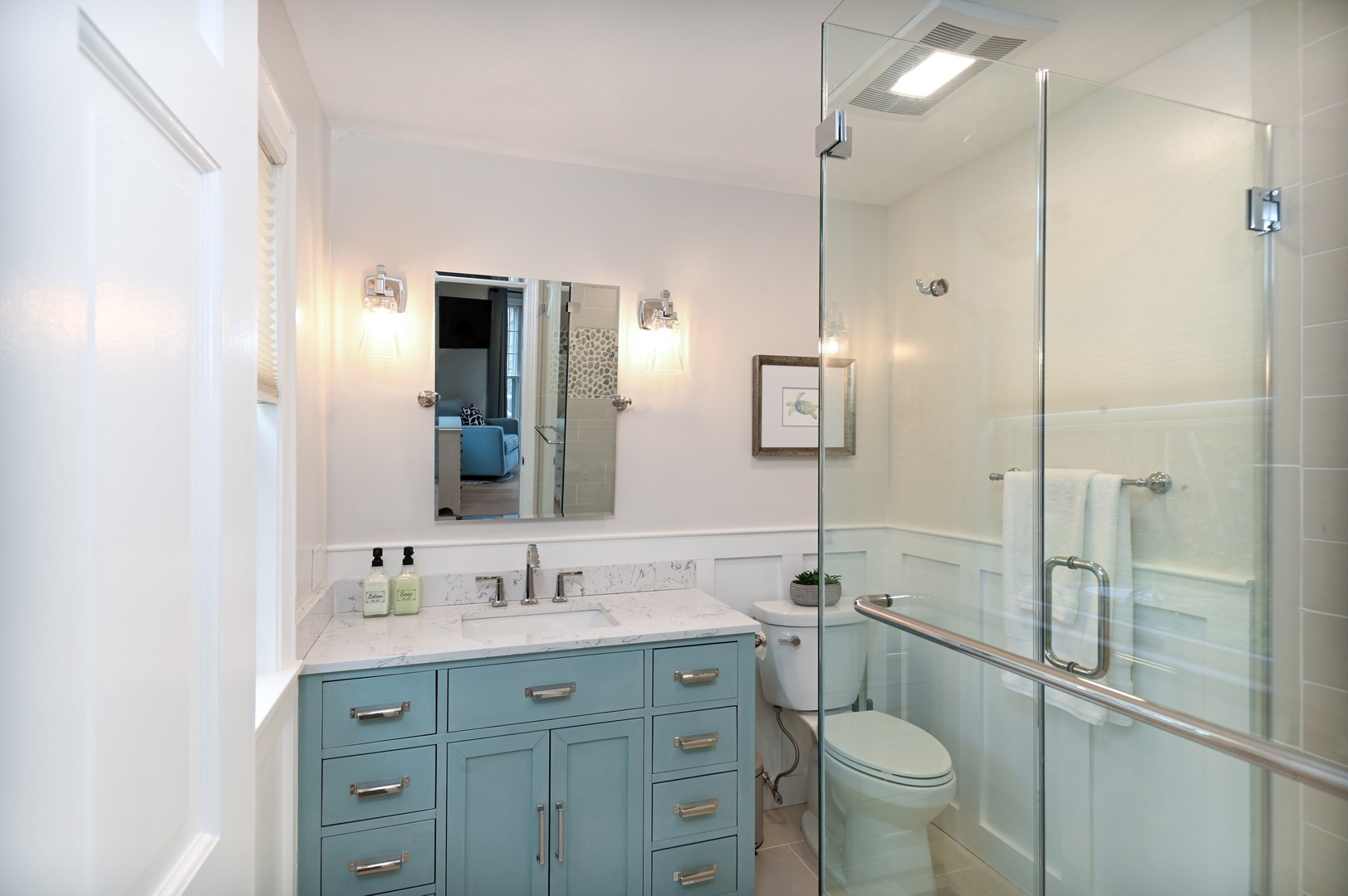 Harbor View’s chic ensuite bath includes a single vanity & luxe glass shower