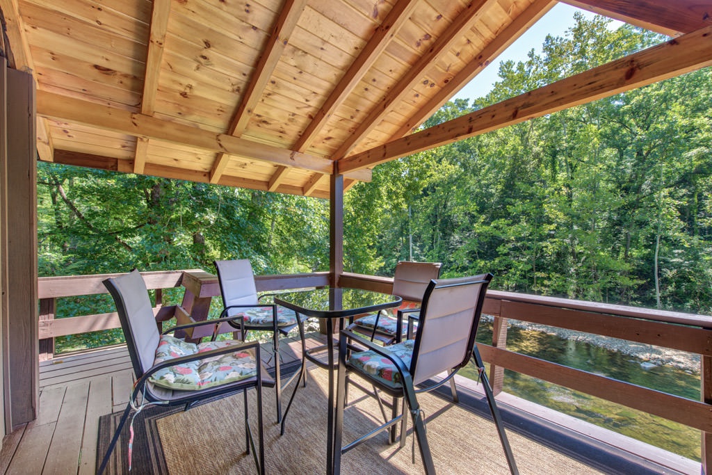 Top deck with outdoor dining furniture on the river