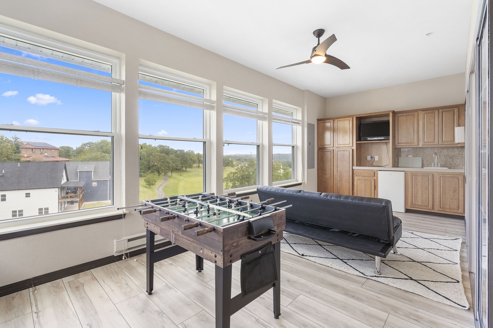 Bright sunroom with foosball, seating area, and TV