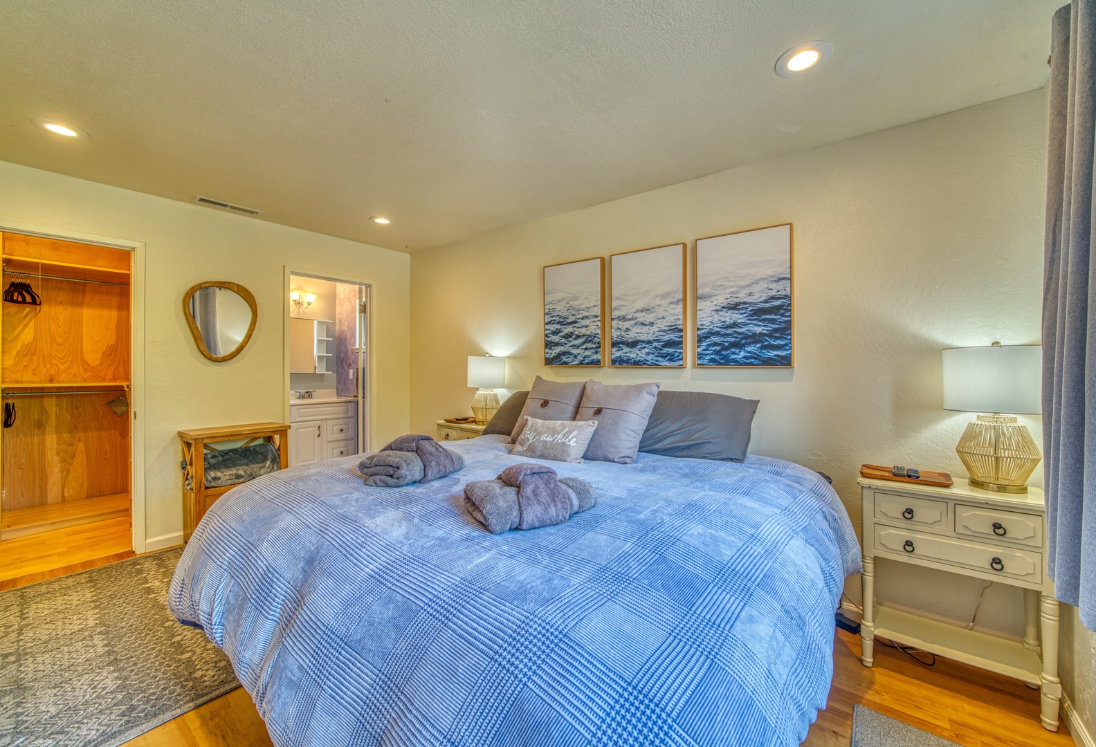 The primary bedroom retreat boasts a king bed, half ensuite, & smart TV