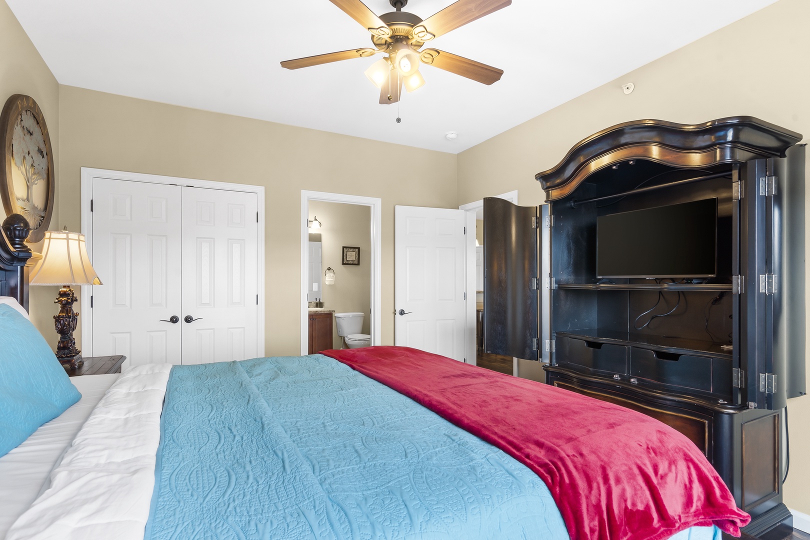 The master suite showcases a regal king bed, private ensuite, & TV