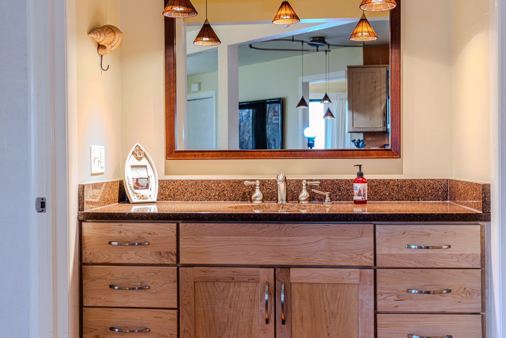 The full bathroom offers a single vanity with storage & glass shower