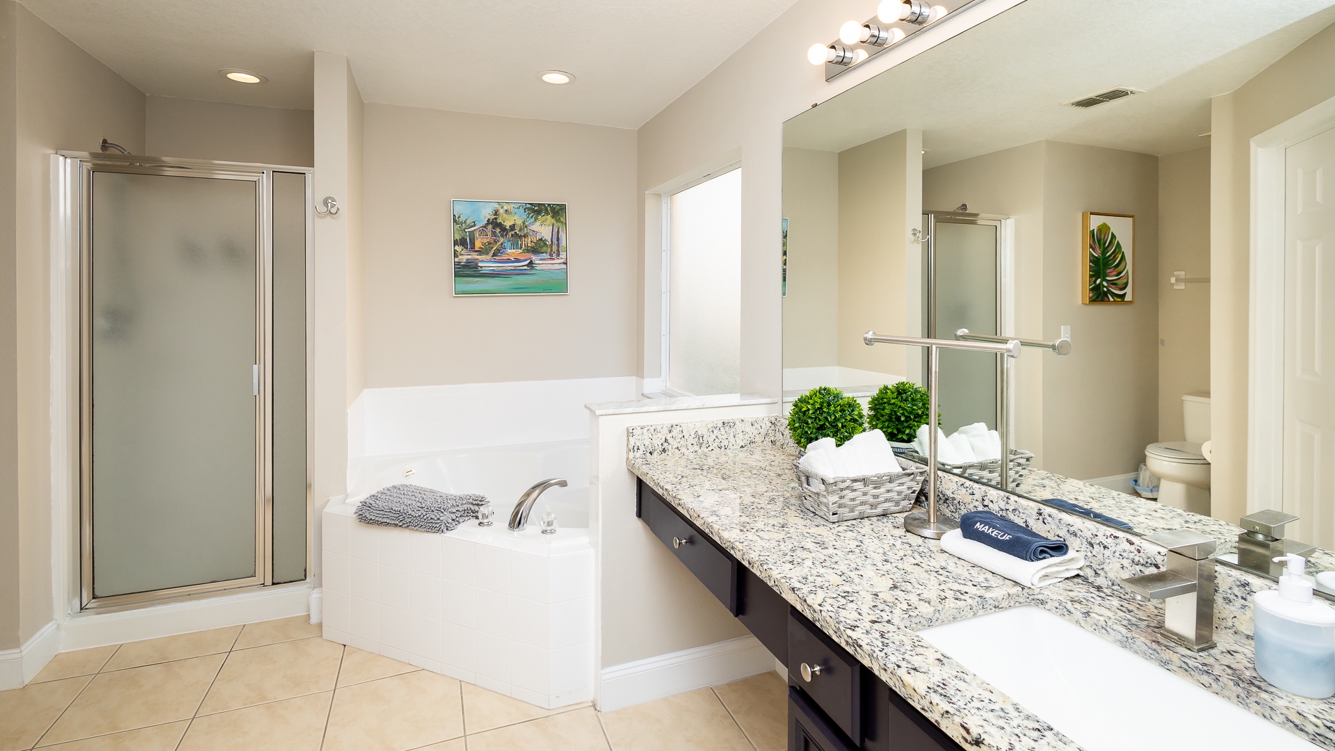 A large single vanity, shower, & soaking tub await in this main-level ensuite