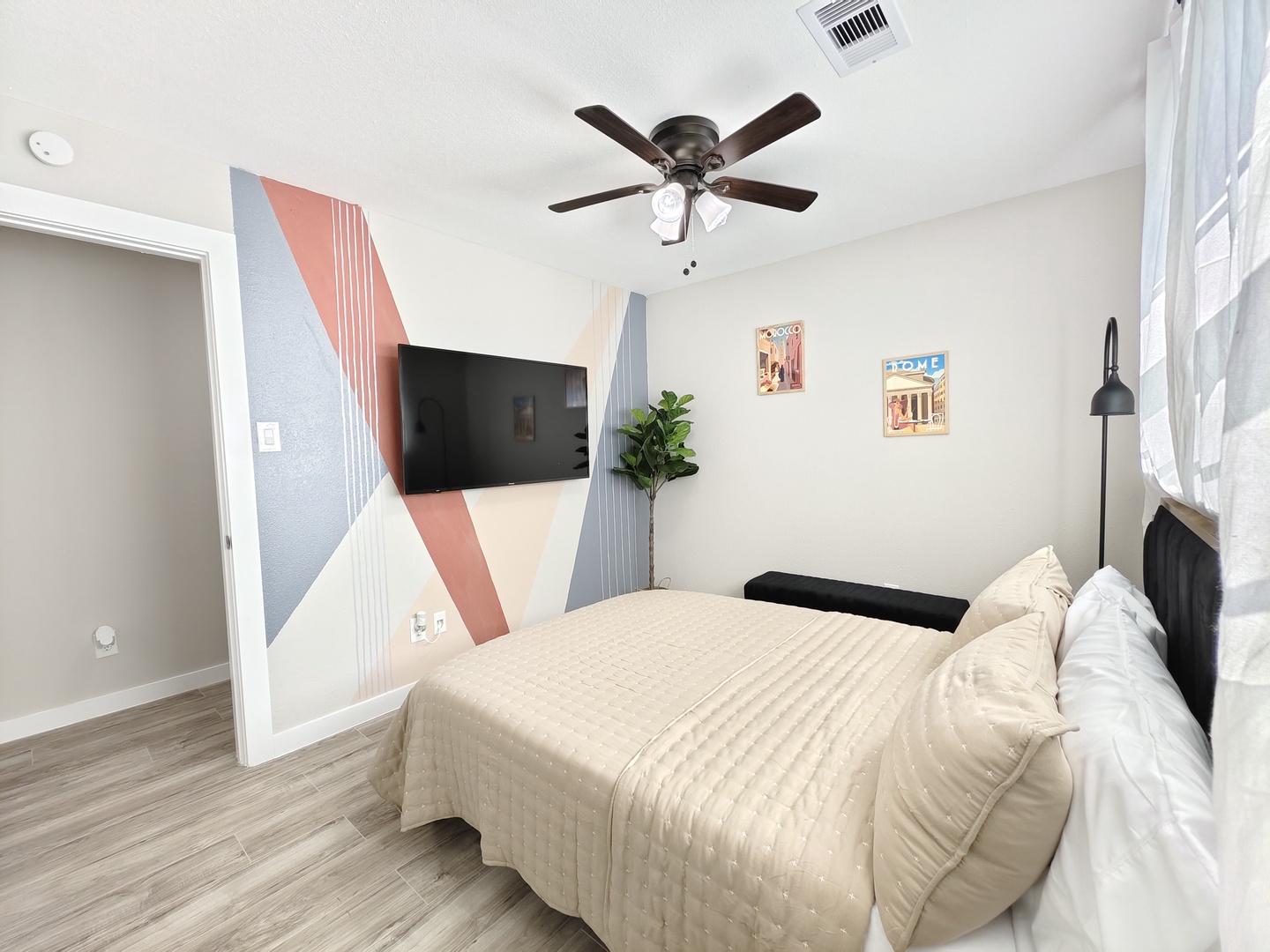 The third bedroom showcases a plush queen-sized bed & Smart TV