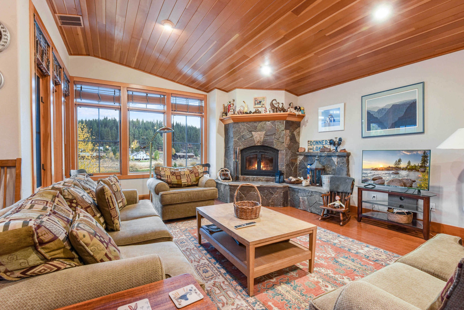 Living room with wood burning fireplace, flat screen TV and mountain views
