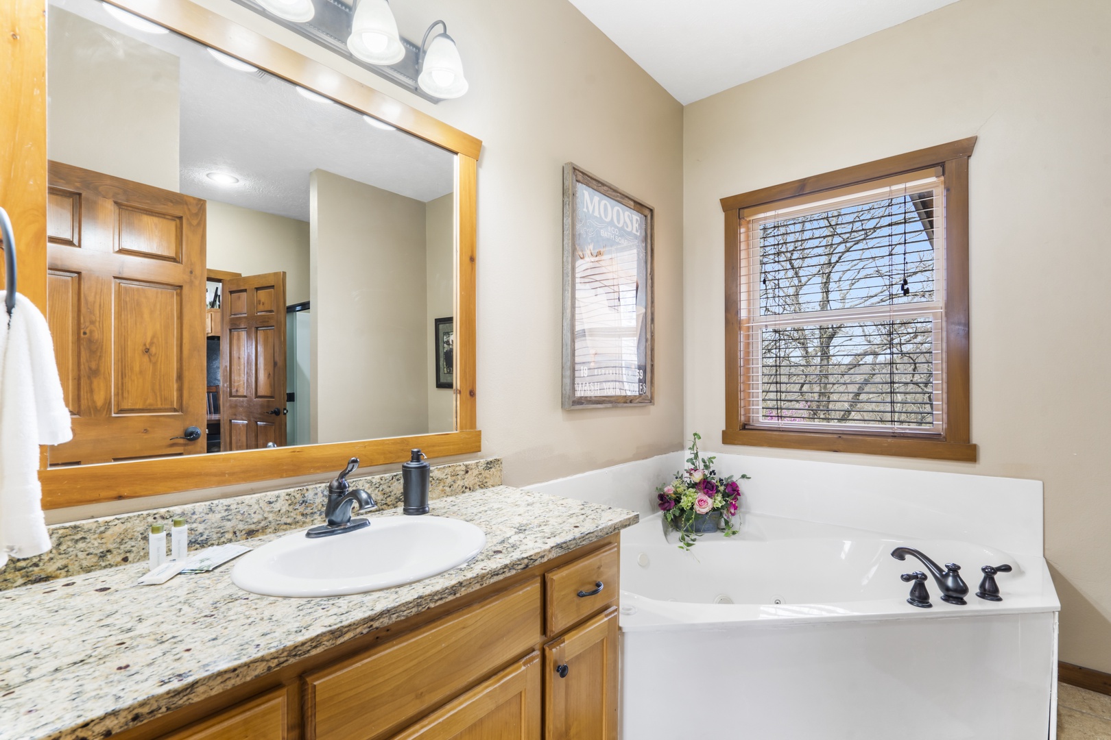 A single vanity, glass shower, & Jacuzzi soaking tub await in this ensuite bath