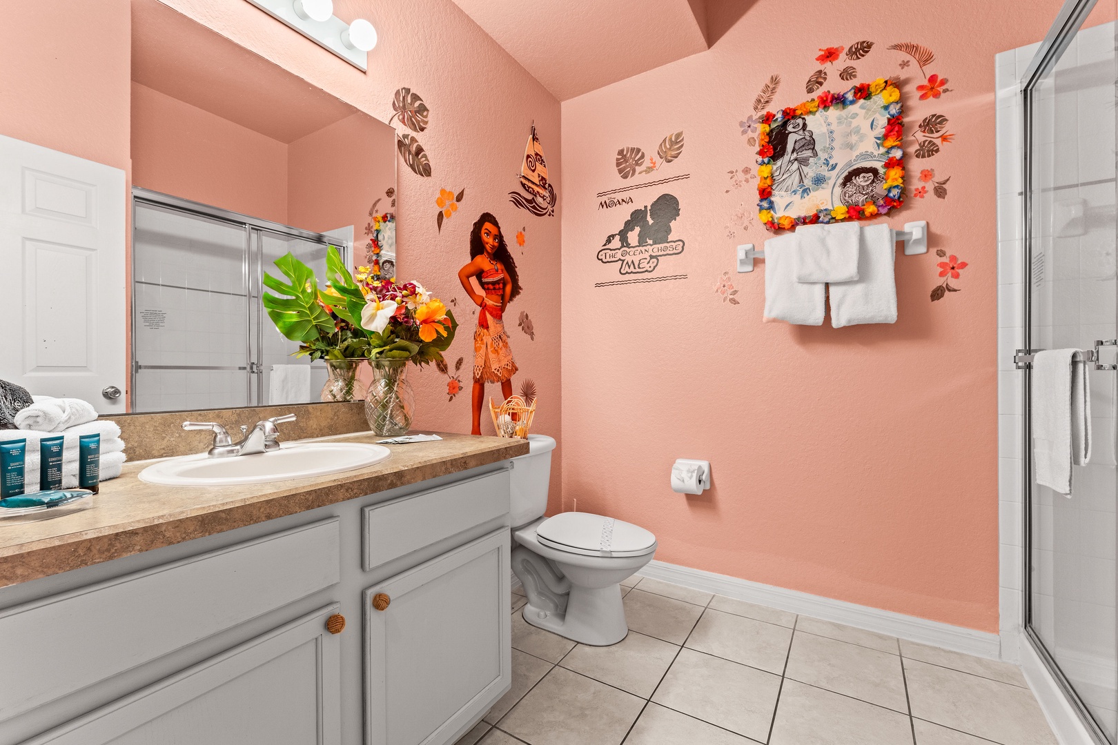 Moana-themed bathroom featuring a single vanity & glass-enclosed shower