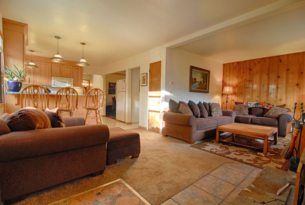 Cozy living room w/ plenty of seating around a wood burning fireplace, TV & DVD player