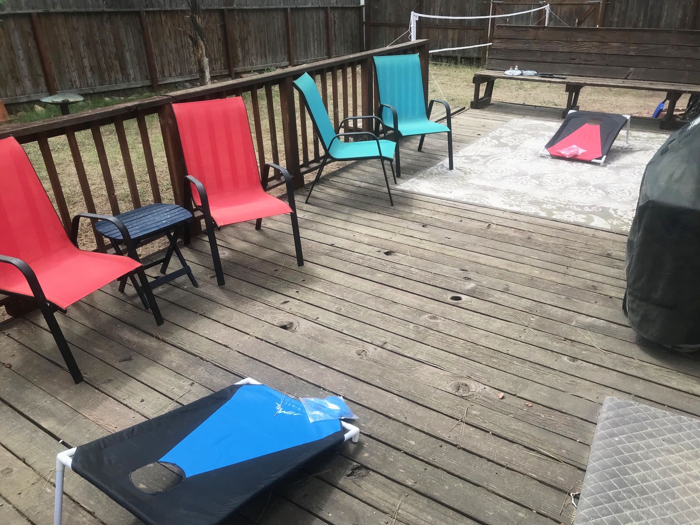 Outdoor seating and cornhole in yard