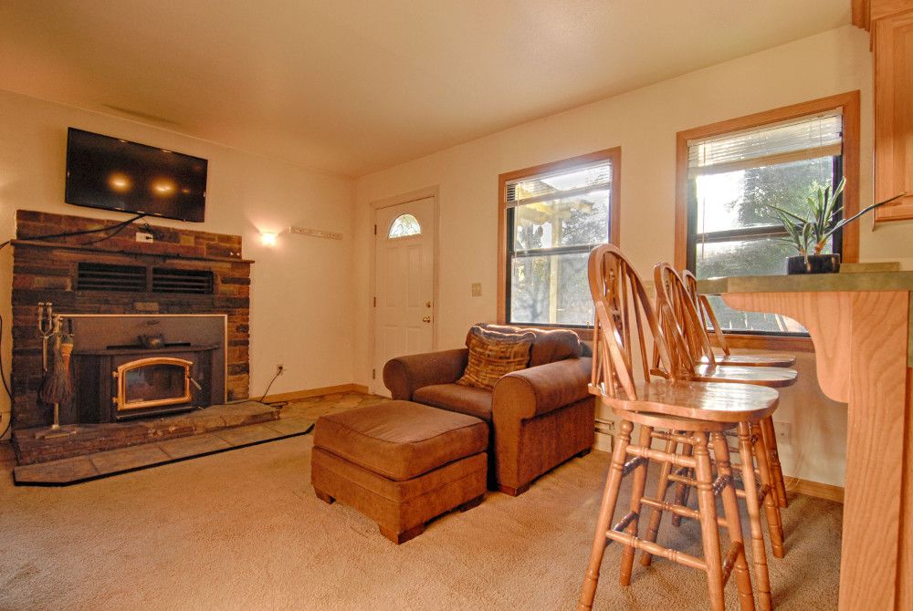 Cozy living room w/ plenty of seating around a wood burning fireplace, TV & DVD player