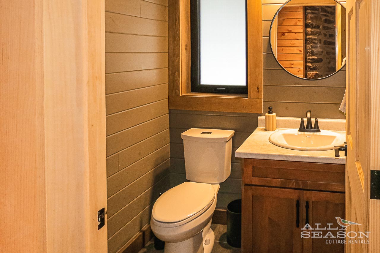 Step into your cozy bathroom with warm wood accents and modern amenities for a relaxing mountain retreat experience.