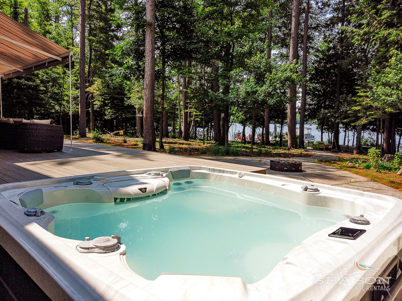 Soak in your private hot tub surrounded by towering trees, with glimpses of the lake sparkling beyond the forest.