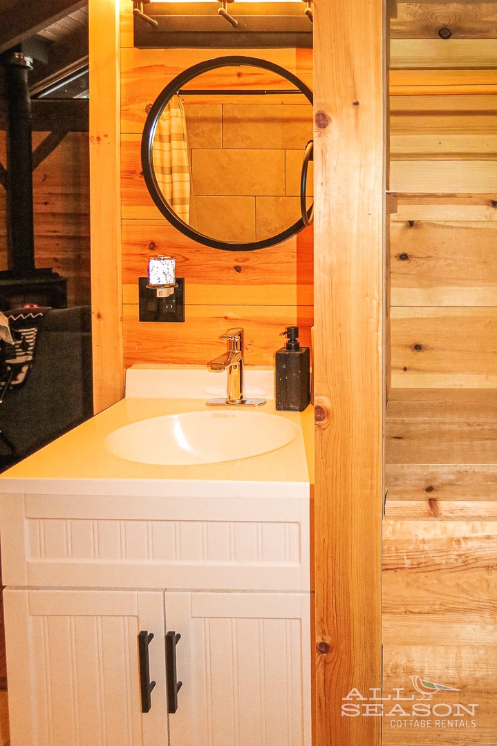 Freshen up in your charming rustic bathroom with warm wood walls, modern amenities, and thoughtful touches.