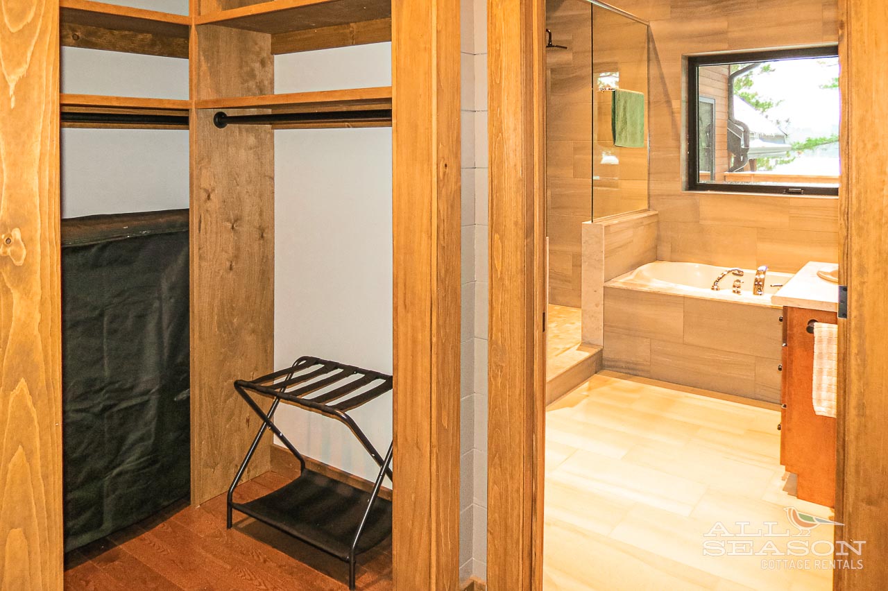 Store your belongings in this spacious wooden closet, then unwind in the adjoining bathroom with its luxurious soaking tub.