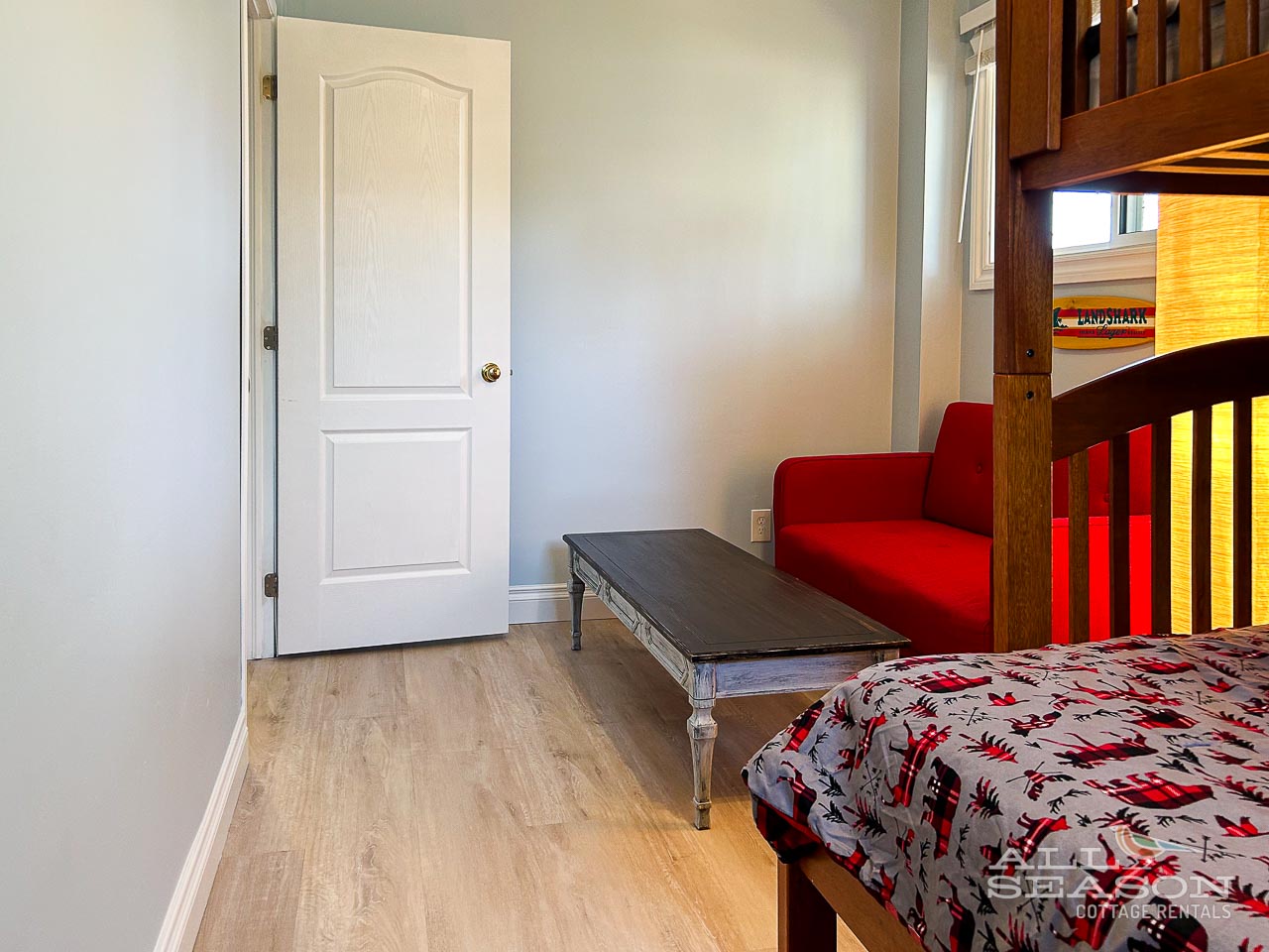 Cozy bunk room where kids can create memories, featuring comfortable bedding and a bright red reading chair for quiet moments.
