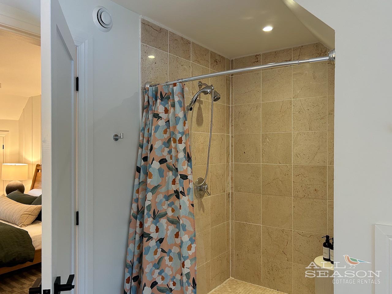 Refresh in your private walk-in shower with warm stone tiles and modern fixtures, perfectly positioned near your cozy bedroom.