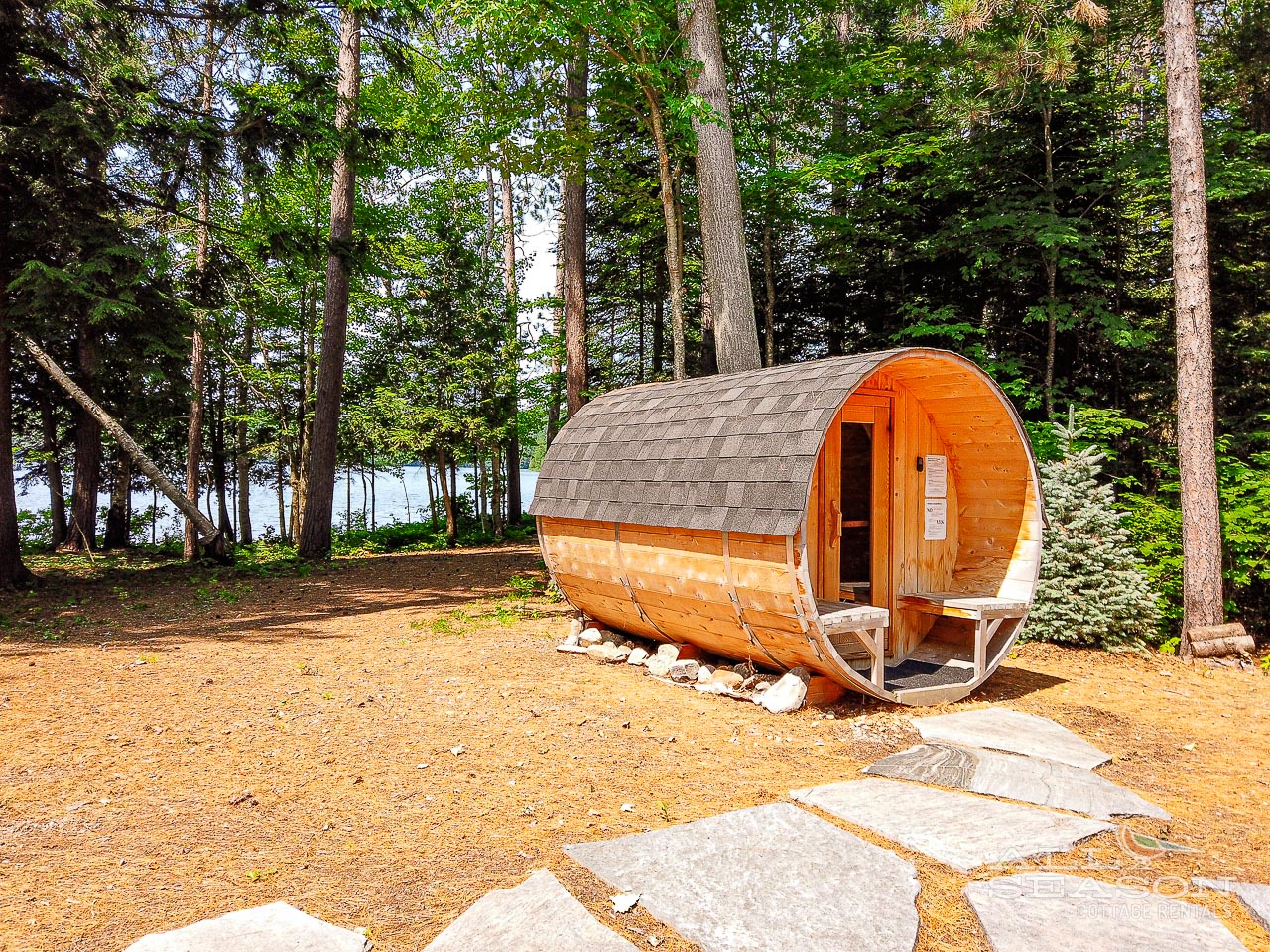 Unwind in your private barrel sauna nestled among towering pines, where forest tranquility meets ultimate relaxation just steps from the shimmering water.