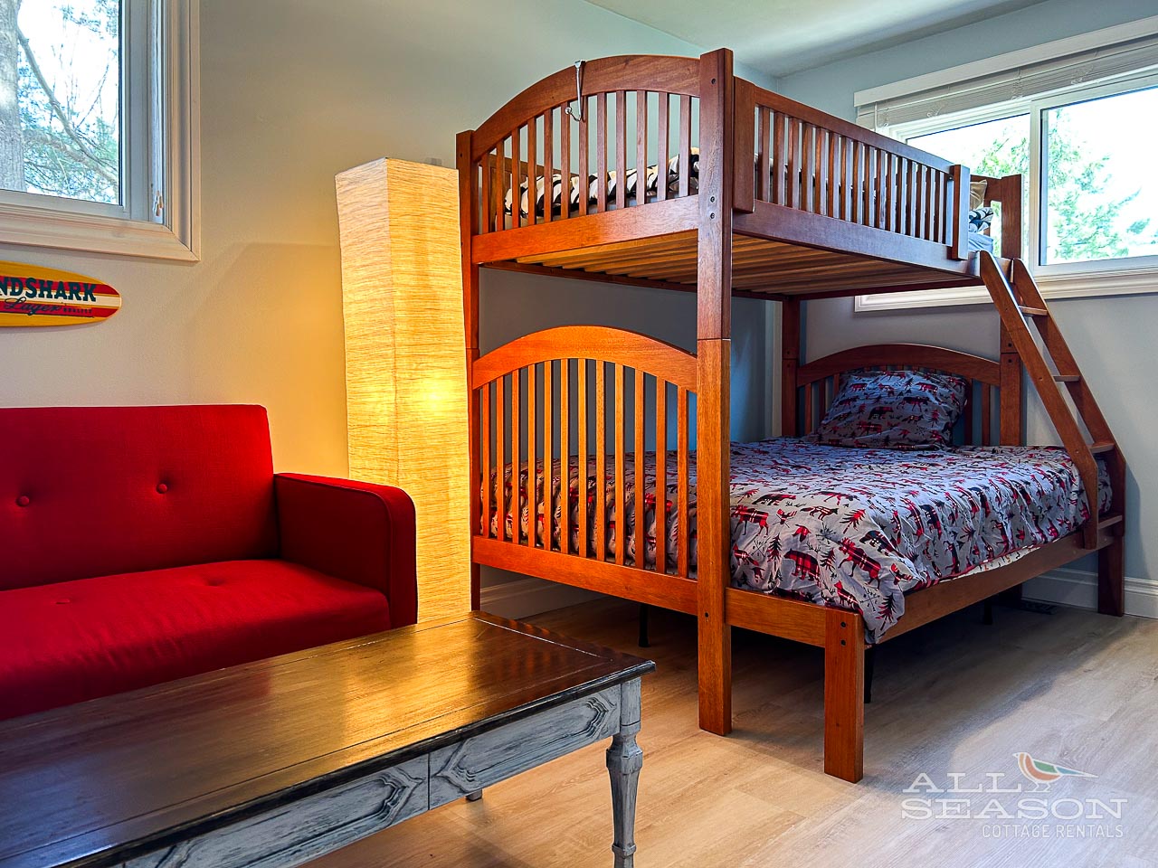 Your kids will love this cozy bedroom featuring sturdy wooden bunk beds and a cheerful red chair for bedtime stories.