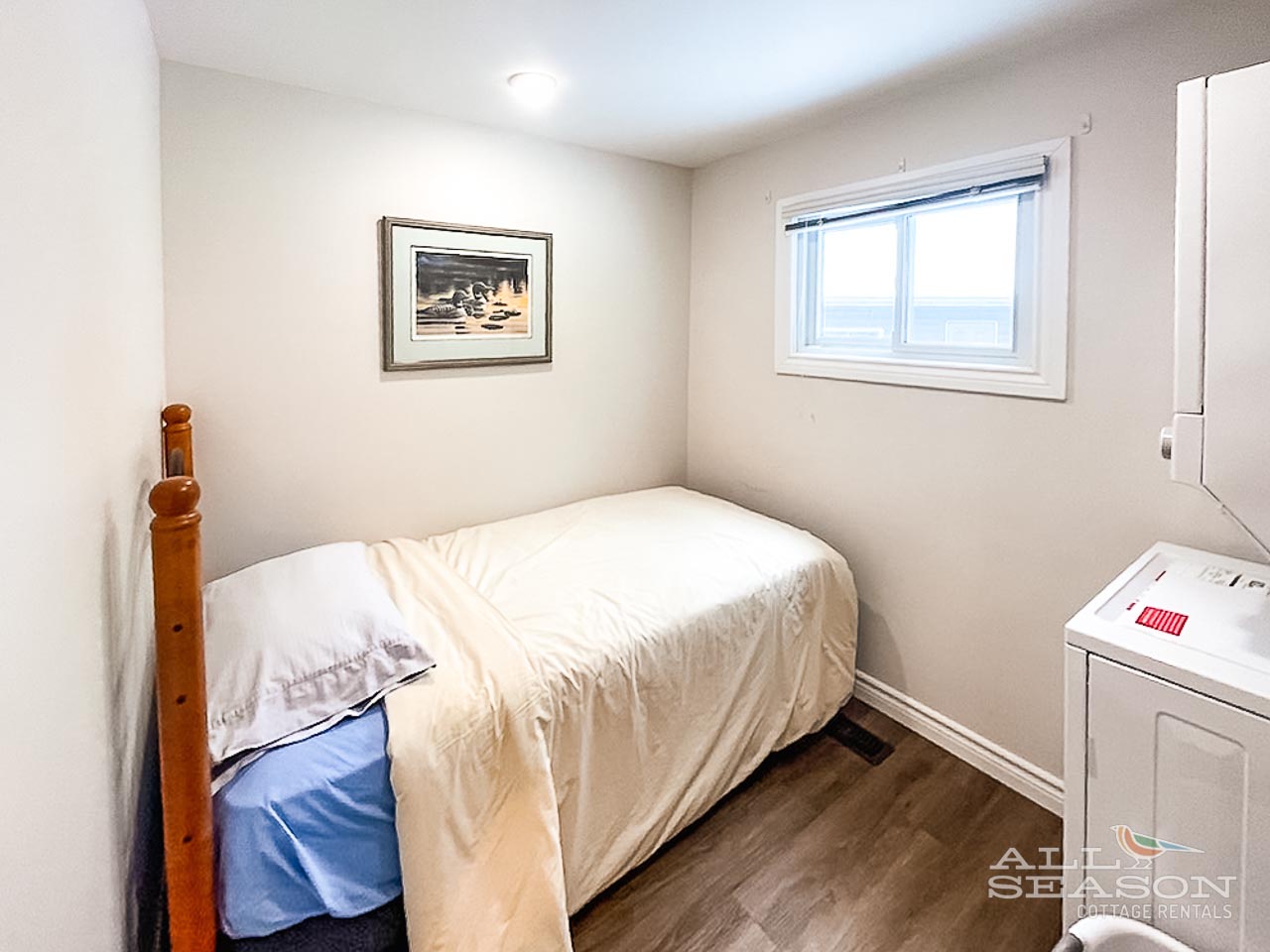 Drift off in your peaceful bedroom featuring crisp white linens and a charming nautical print—your restful retreat awaits.