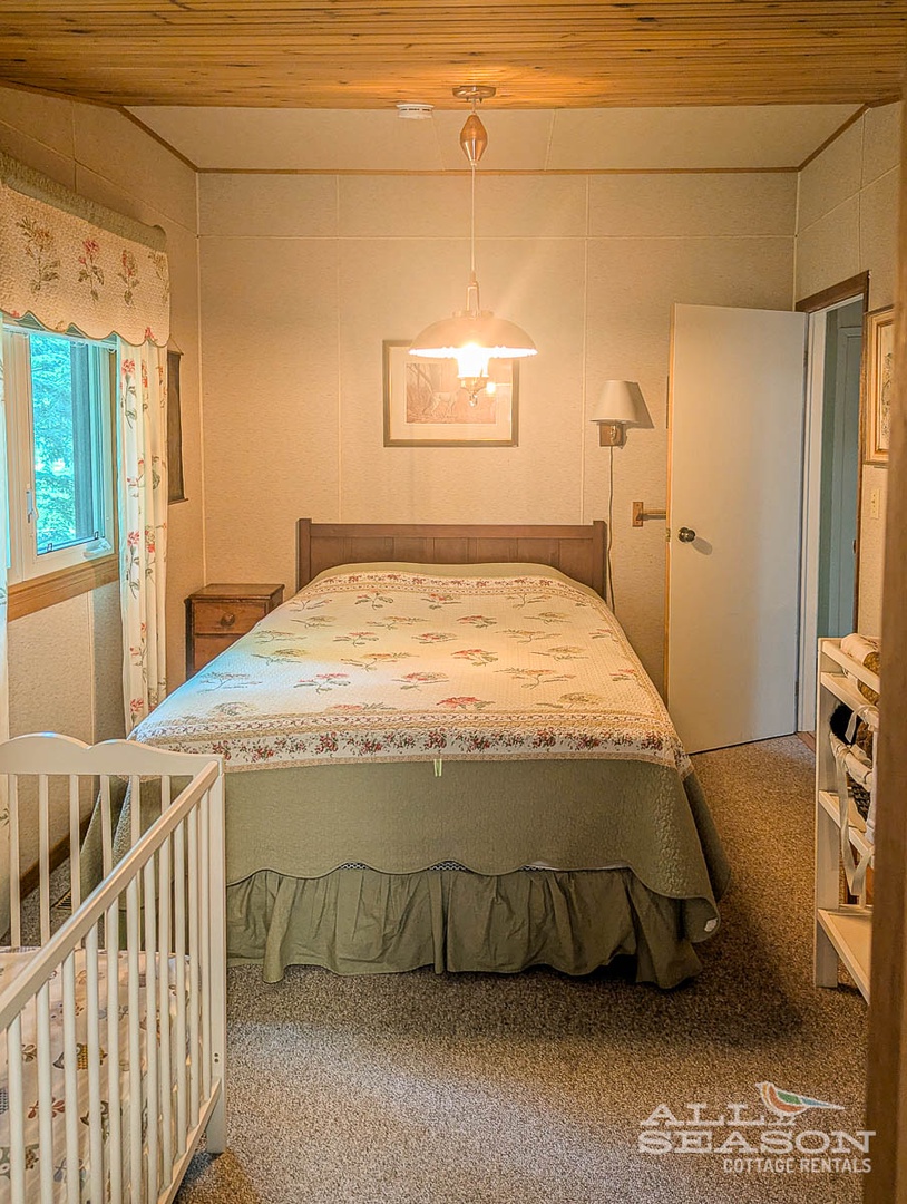 This room has a Queen bed + a crib.
