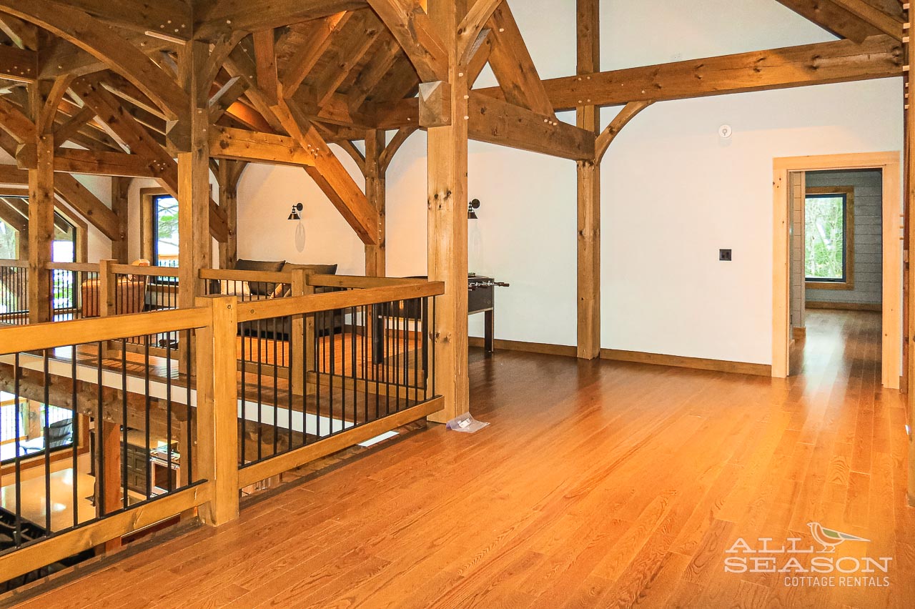 Step into this stunning timber-framed loft where exposed beams create cathedral-like grandeur above gleaming hardwood floors beneath your feet.