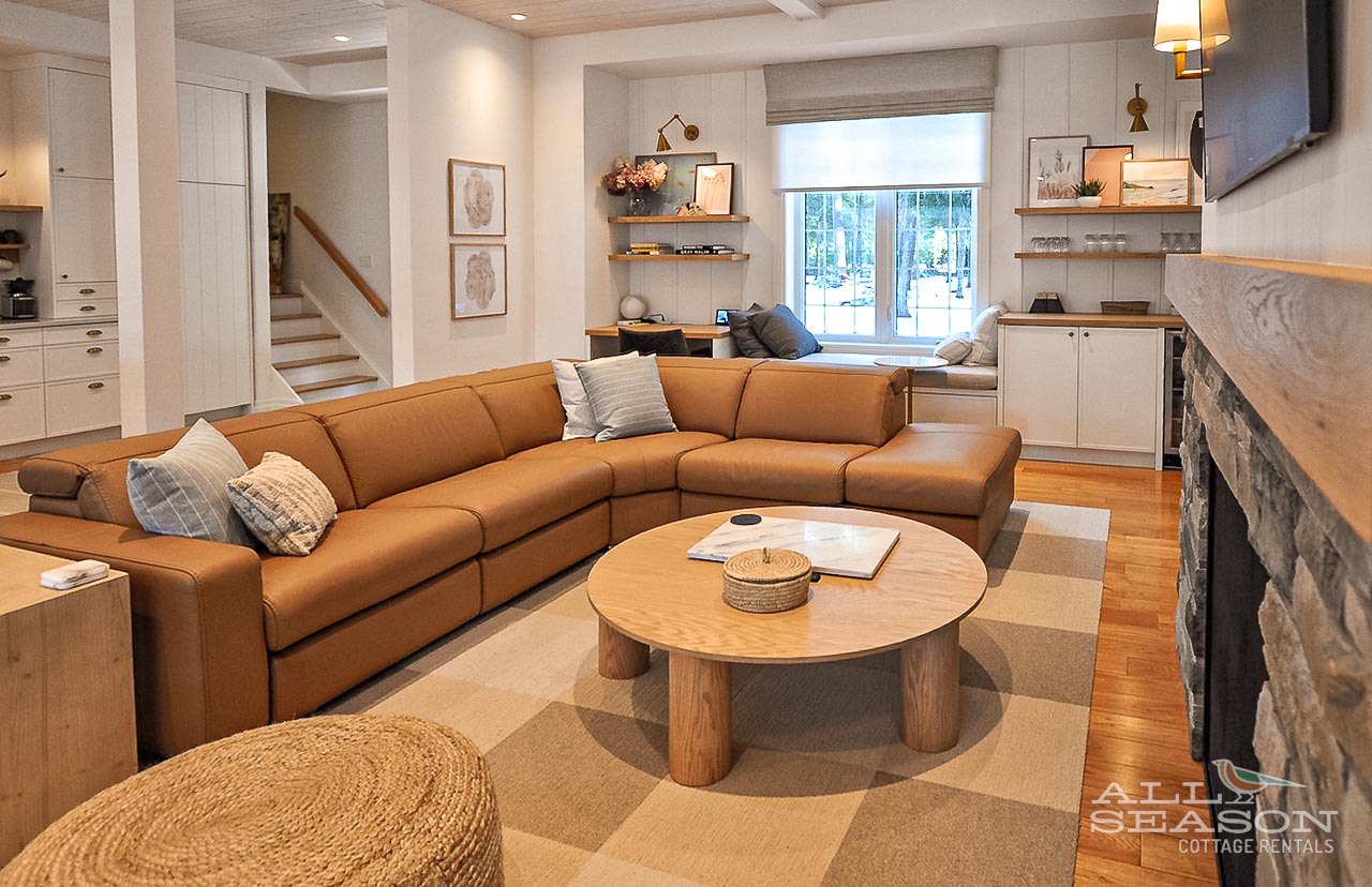Sink into this plush sectional sofa where warm tones and modern comfort create your perfect spot for evening conversations by the stone fireplace.