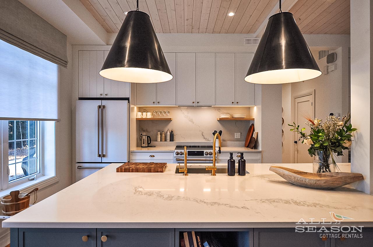 Cook and create in this stunning modern kitchen with marble counters, gleaming appliances, and warm pendant lighting.