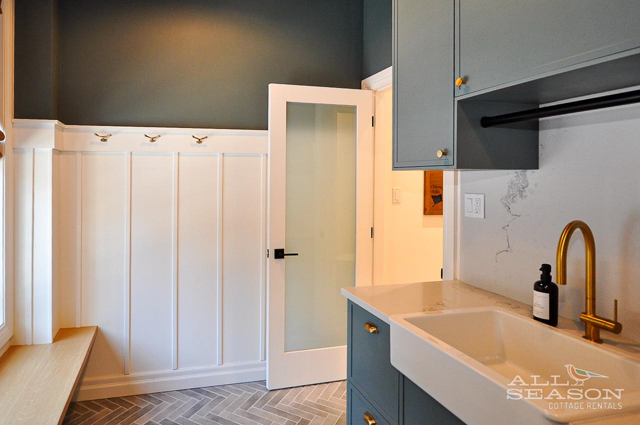 Your stylish kitchen features elegant marble counters, brass fixtures, and custom blue cabinetry for memorable meal prep.