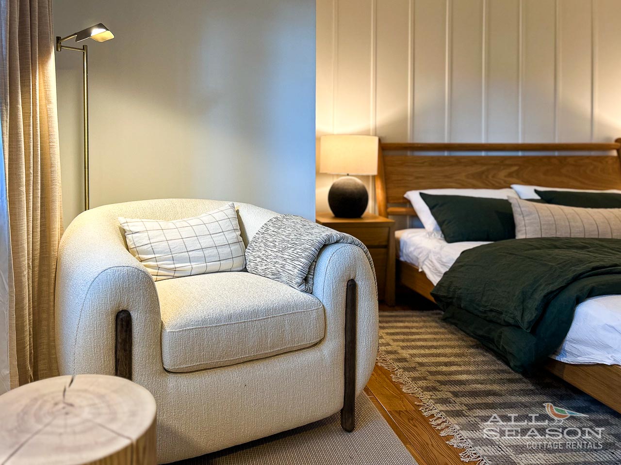 Sink into your cozy reading chair beside the comfortable bed, where soft lighting creates the perfect atmosphere for evening relaxation.