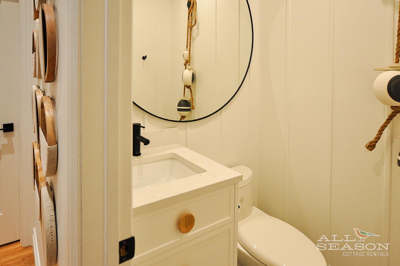Your stylish powder room features a sleek vessel sink and nautical rope accents, creating a charming coastal vibe.