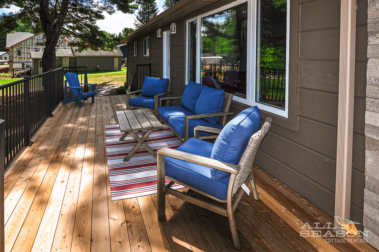 Your private deck awaits with plush blue seating and warm wood tones, perfect for morning coffee or sunset relaxation.