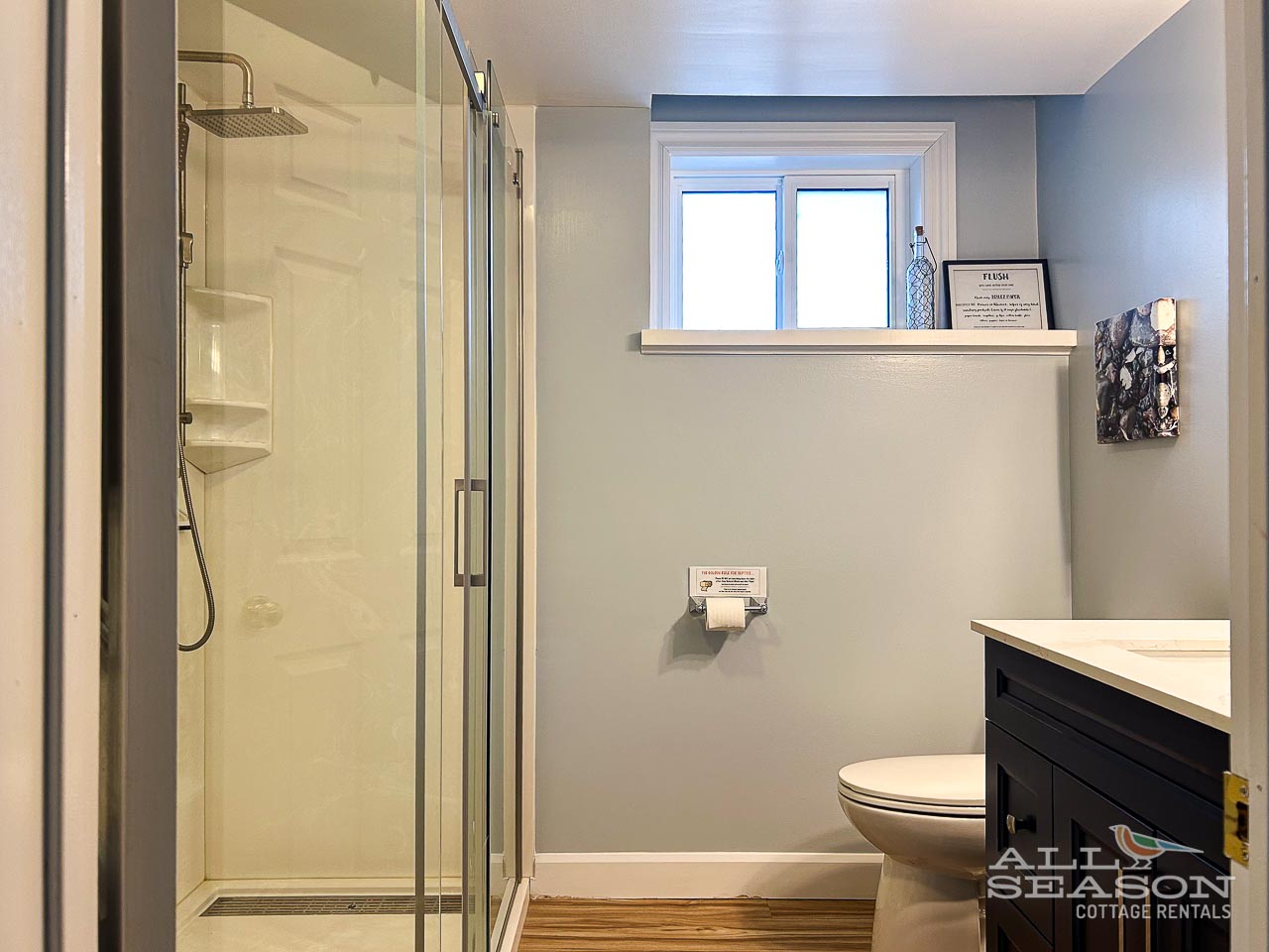 Refresh in your modern bathroom featuring a spacious glass shower, stylish vanity, and natural light from the window.