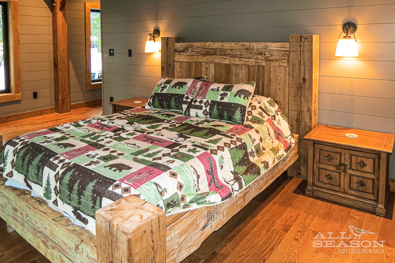 Rest peacefully in this cozy bedroom featuring rustic wood furniture and charming woodland-themed bedding that brings nature indoors.