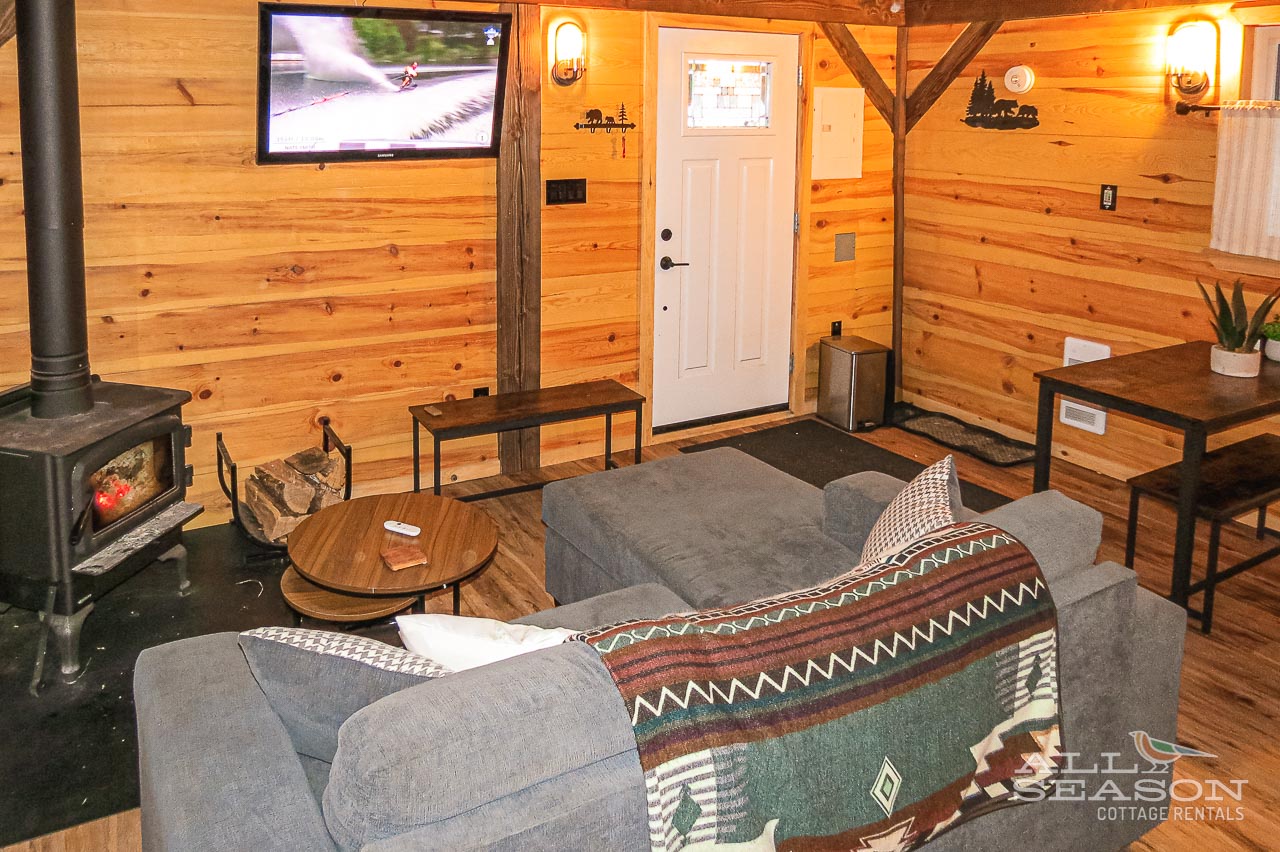 Cozy up in your rustic retreat with warm wood walls, crackling fireplace, and comfortable seating perfect for mountain evenings.