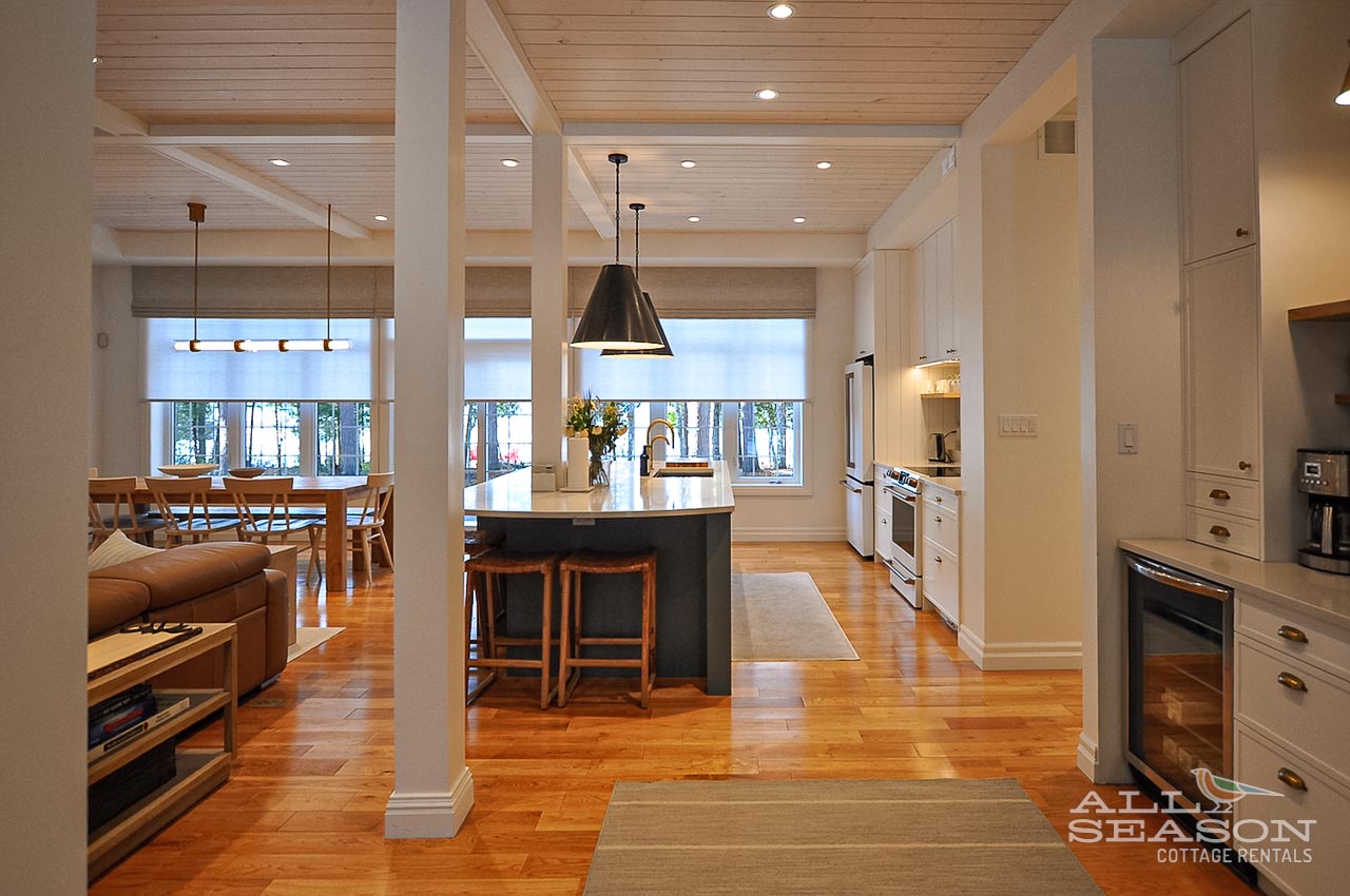 Your spacious kitchen flows seamlessly into the dining area, featuring warm wood beams overhead and a welcoming island perfect for morning coffee.