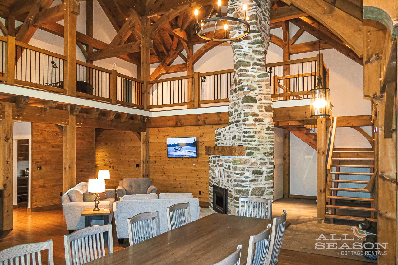 Cozy up in your rustic retreat with soaring timber beams, stone fireplace, and comfortable seating perfect for memorable evenings.