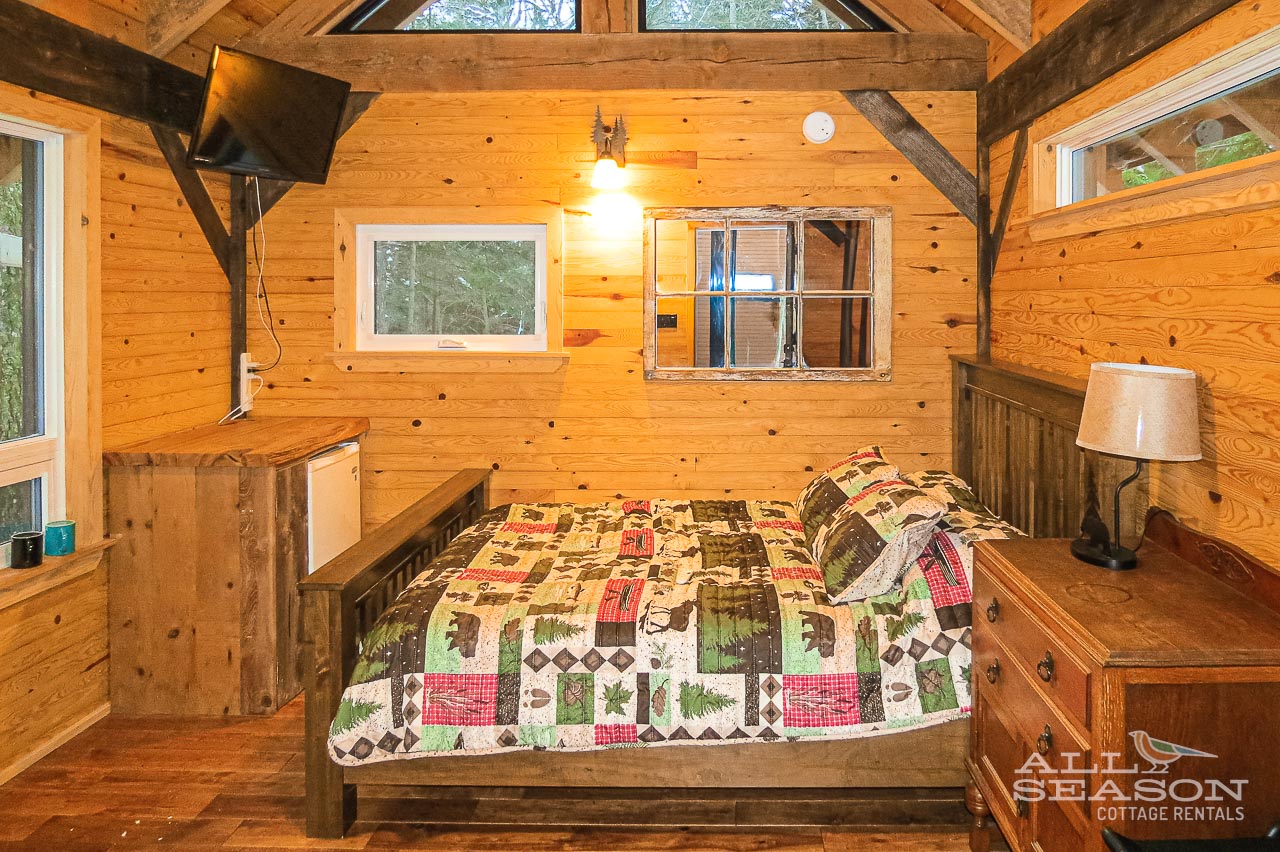 Cozy under exposed wooden beams in your rustic loft bedroom, where handcrafted furniture meets charming quilted comfort.
